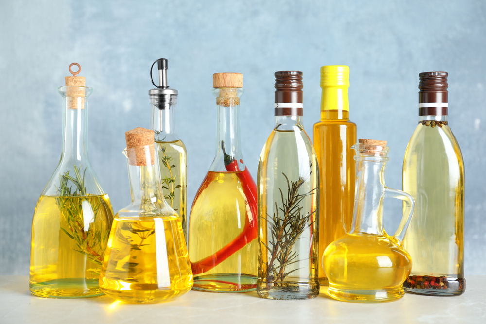 Different,Sorts,Of,Cooking,Oil,In,Bottles,On,Light,Grey